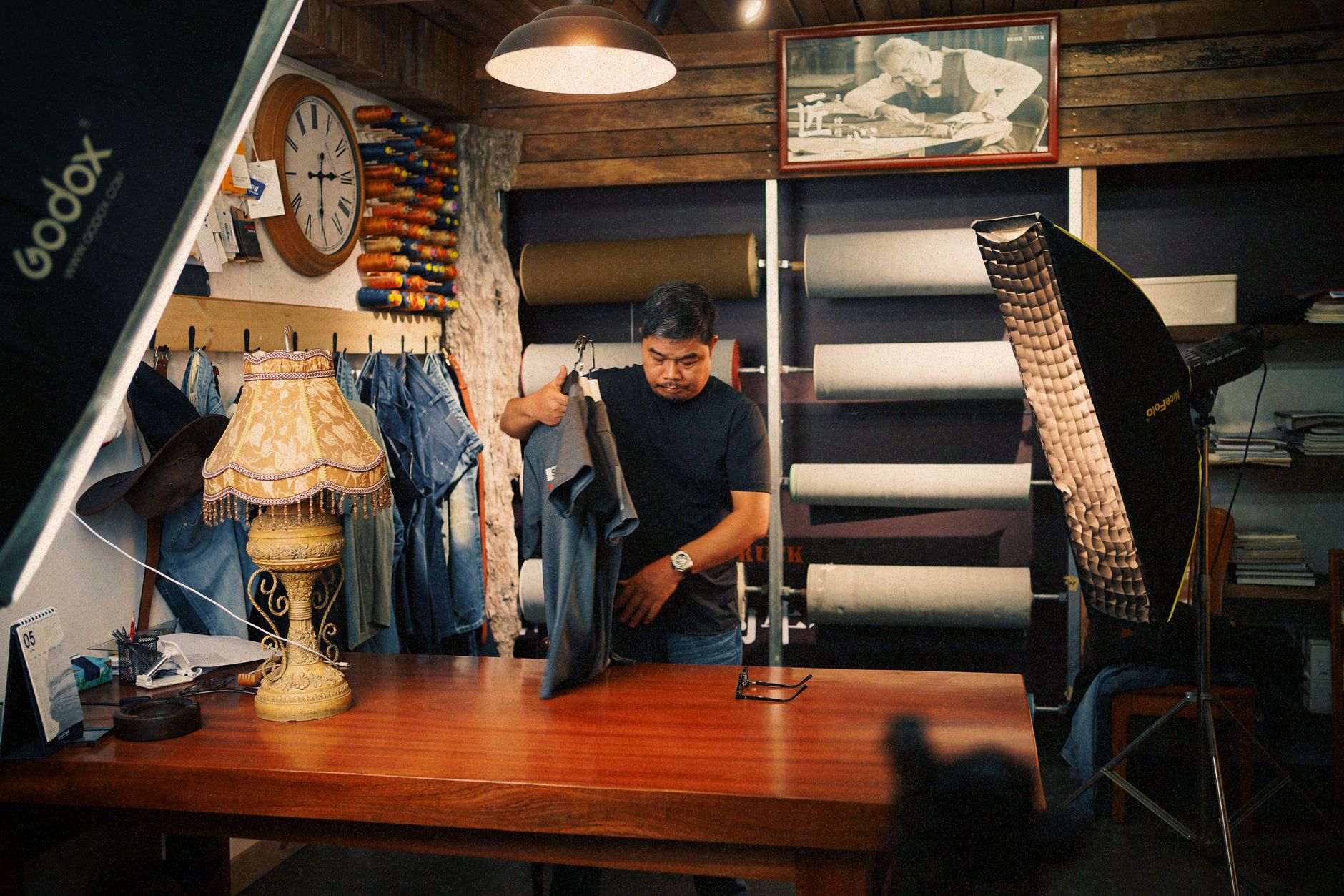 Tailor holding garments behind a counter